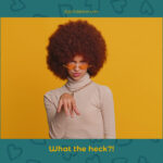 A person with a large curly afro and wearing sunglasses makes a confused expression with their hand raised. The background is yellow, and text at the bottom reads "What the heck?!". 